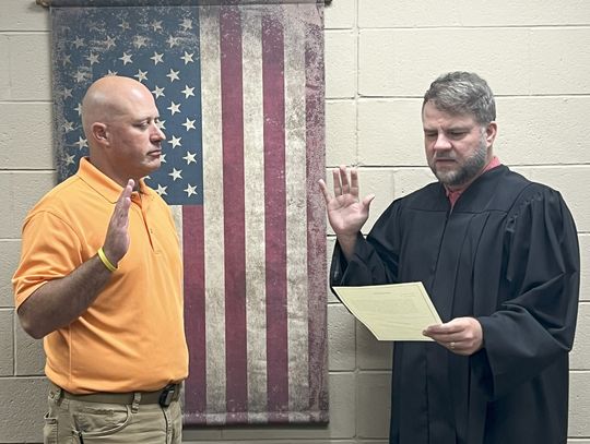 Newly appointed Atoka County Assessor Trey Harbin (left) is administered the oath of office by Judge Preston Harbuck following the Commissioner Meeting on Monday